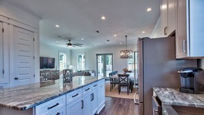 A spacious kitchen with a large island, white cabinetry, and stainless steel appliances. - Beachin' *HeatedPool&Spa*Golf Cart*Bikes*BeachSvc* (Destin)