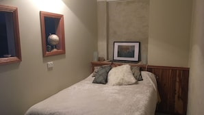 Un dormitorio con una cama, un cuadro en la pared y un globo terráqueo en un estante.