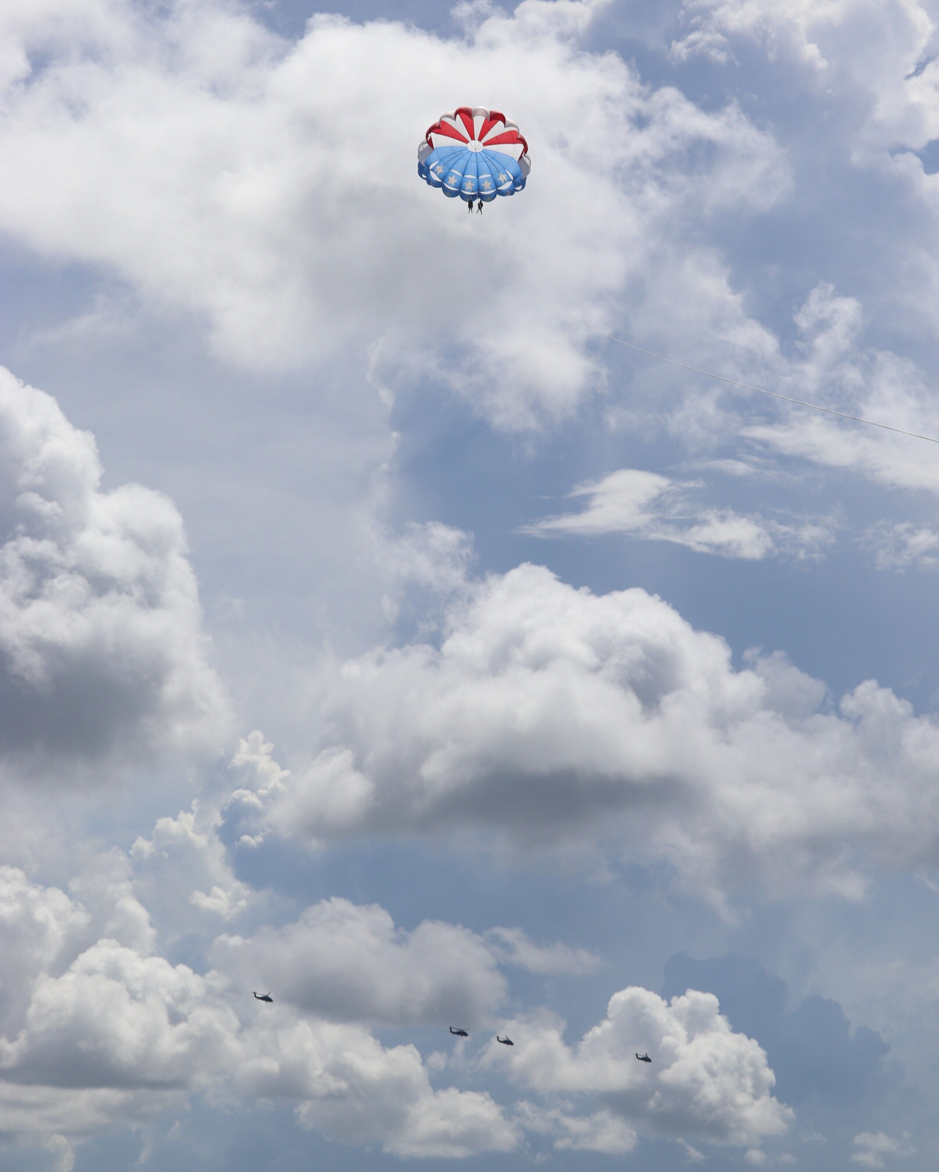 A sky with clouds and a parachute.