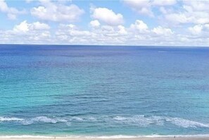 A beach with clear blue water and a sandy shore.