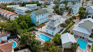 Un quartier résidentiel situé sur la côte, composé de plusieurs maisons à deux étages, d’une grande piscine et offrant une vue sur l’océan.