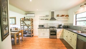 A kitchen with wooden cabinets, a stove, microwave, and a sink. - ABBEVILLE IN BRIGHT: Bright (Bright)