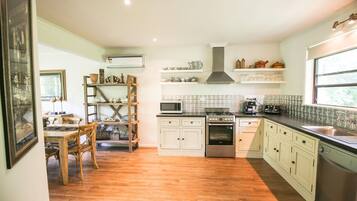 A kitchen with wooden cabinets, a stove, microwave, and a sink.