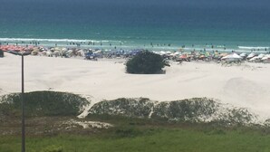 En strand med parasoller og mennesker.