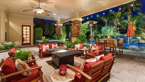 Eine Außenpatio-Terrasse mit Sitzgelegenheiten, einem Feuerkorb und einem Pool.