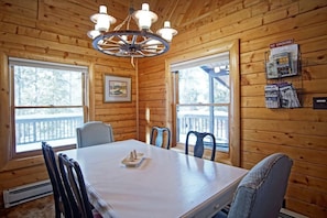 A wooden cabin with a dining table, chairs, a chandelier, and a 'No Smoking' sign. - Cabin Close to Beacon Landing Marina w/ Wraparound Deck, Outdoor furniture, Gas Grill (Grand Lake)