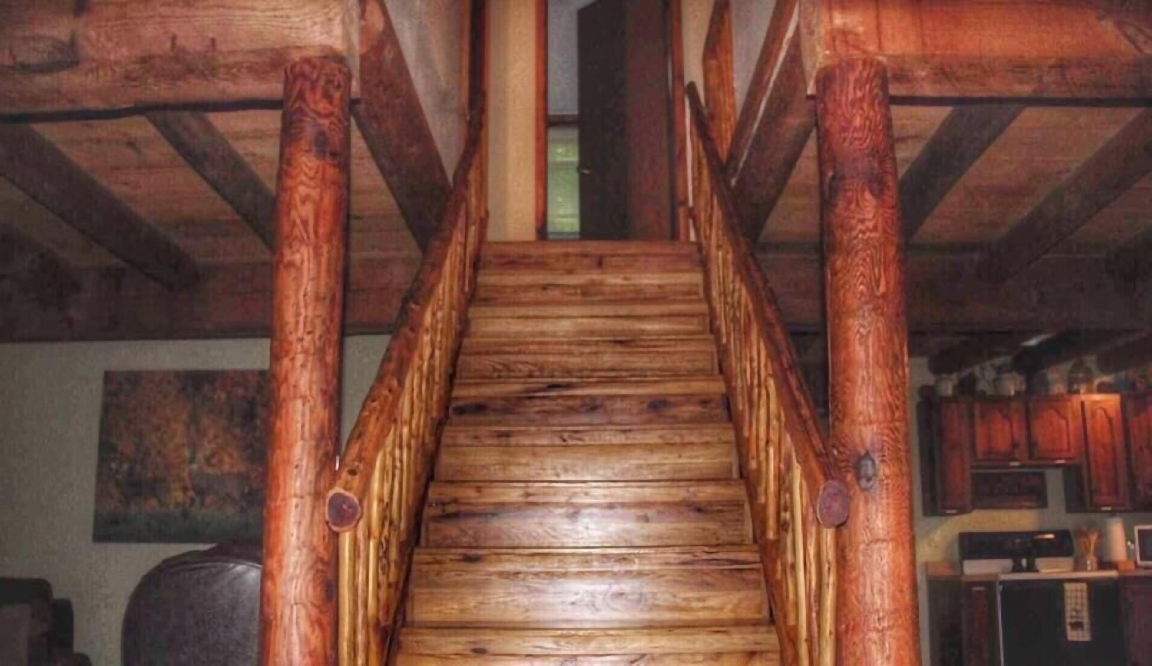Un escalier en bois, au design rustique, menant à un niveau supérieur.