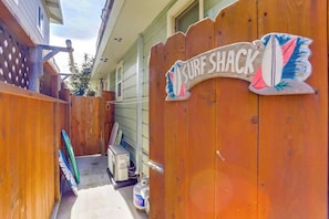 Ein hölzernes Tor mit einem Schild, auf dem 'SURF SHACK' steht, und einer Surfbrett-Dekoration.