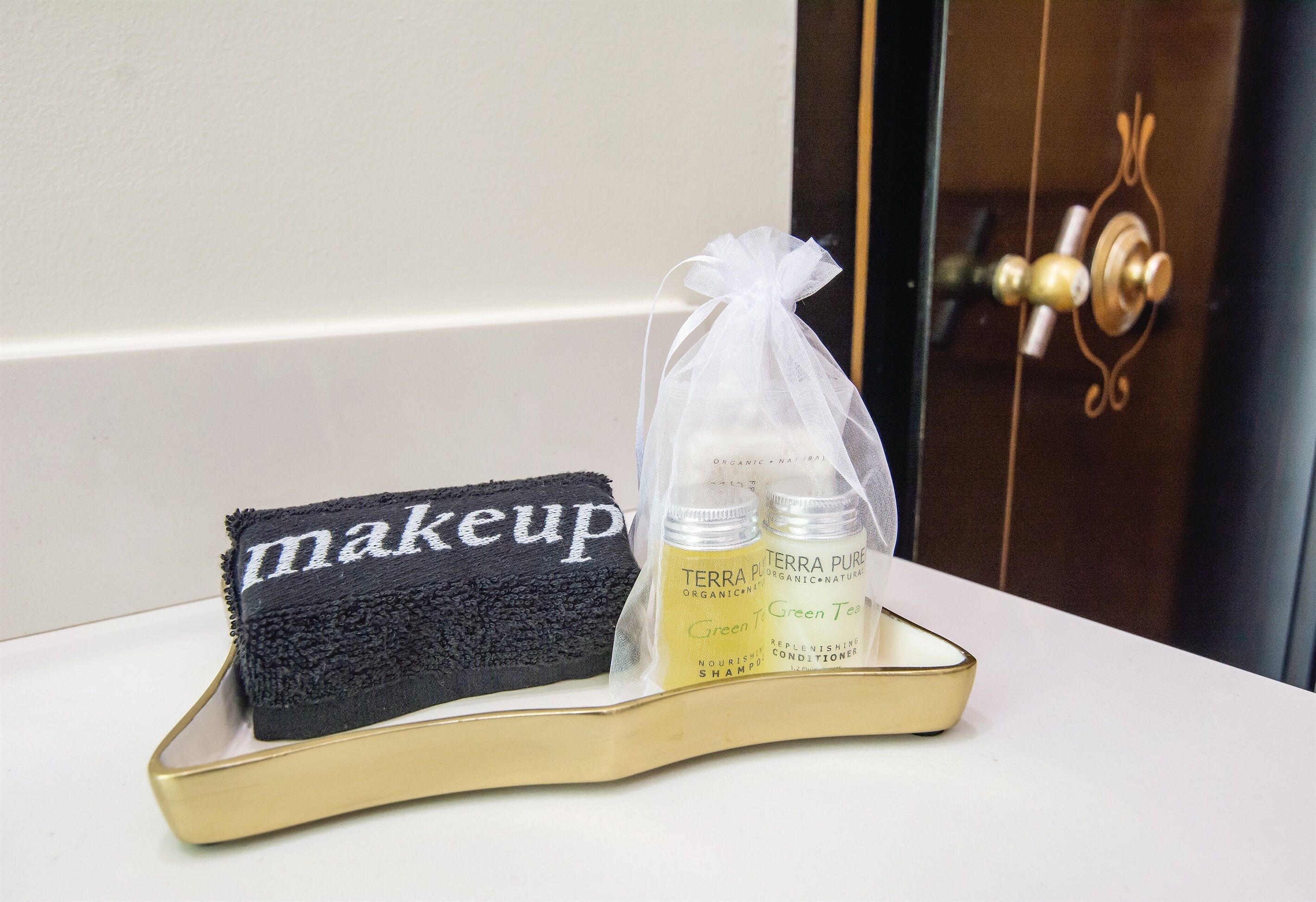 A tray with a black towel and two bottles of Terra Pure shampoo and conditioner.