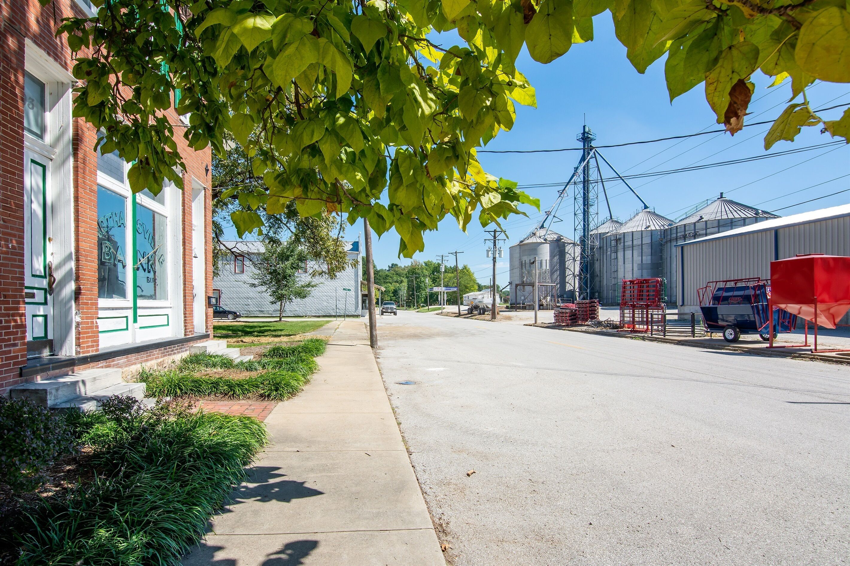 A street view with a building labeled "ST. VINCENT BANK" and a sidewalk with greenery.