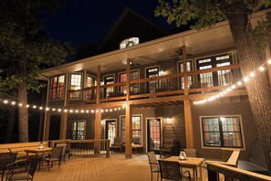 A two-story building with a balcony, outdoor seating area, and string lights. - Secluded 40 Acres Near Table Rock, Stunning Views, Games, Community Pool & Car Charger (Blue Eye)