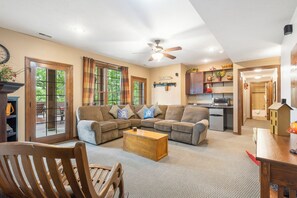 A living room with a sectional sofa, a wooden coffee table, and a dining area with a table and chairs. - Secluded 40 Acres Near Table Rock, Stunning Views, Games, Community Pool & Car Charger (Blue Eye)