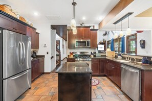 A modern kitchen with stainless steel appliances, wooden cabinets, and a central island. - Secluded 40 Acres Near Table Rock, Stunning Views, Games, Community Pool & Car Charger (Blue Eye)