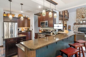 A modern kitchen with a central island, stainless steel appliances, and pendant lighting. - Secluded 40 Acres Near Table Rock, Stunning Views, Games, Community Pool & Car Charger (Blue Eye)