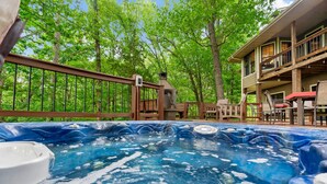 A hot tub surrounded by a deck with outdoor furniture, overlooking a forested area. - Secluded 40 Acres Near Table Rock, Stunning Views, Games, Community Pool & Car Charger (Blue Eye)
