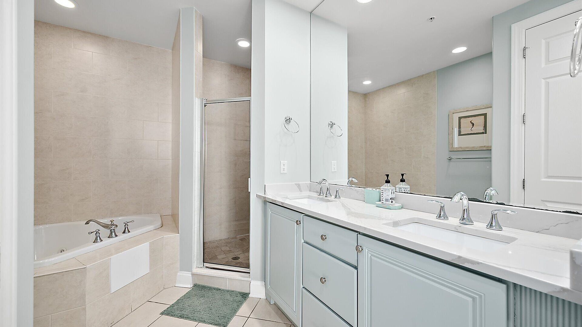 Un baño moderno con cabina de ducha, bañera y tocador con un espejo grande.