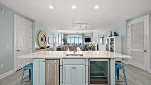 A spacious kitchen with a large island, built-in appliances, and a view to the outdoors.