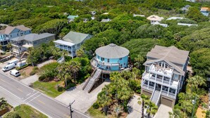 A residential area with houses surrounded by dense greenery and a clear sky. - Mountain to Sea - Direct Beach Access -Ocean Views - 4BD +Bonus Bedroom (Folly Beach)