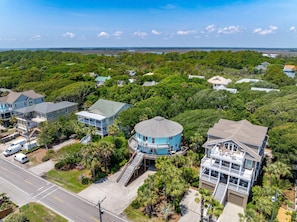 A residential area with houses surrounded by dense greenery and a clear sky. - Mountain to Sea - Direct Beach Access -Ocean Views - 4BD +Bonus Bedroom (Folly Beach)