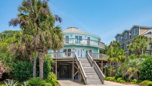 A large, two-story building with a curved roof and a balcony on the second floor. - Mountain to Sea - Direct Beach Access -Ocean Views - 4BD +Bonus Bedroom (Folly Beach)