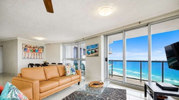 Un salon comprenant un canapé, un coin repas et un balcon avec vue sur l’océan.