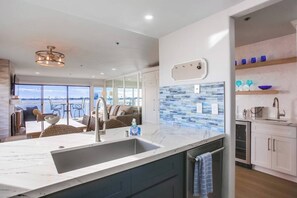Una cucina moderna con una grande isola, vista sull'esterno e zona pranzo panoramica.