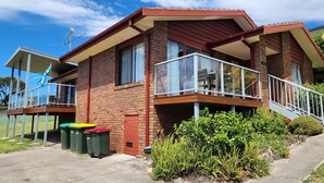 A two-story house with a balcony, brick exterior, and a visible chimney. - Tura Views, 3 BR House (Tura Beach, Merimbula)
