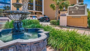 Un hotel con una fuente, palmeras y un letrero que indica 6000 habitaciones disponibles.