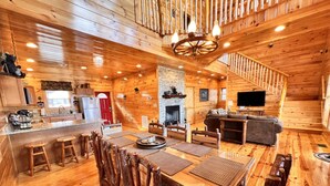 Ein Holzblockbau mit Essbereich, Küche, Wohnzimmer und einer Treppe.