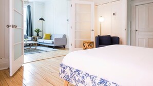 A bedroom with a large bed, a sofa, a chair, and a lamp. - MTLVR #08 | 10 min to downtown, terrace, A/C (Montreal)