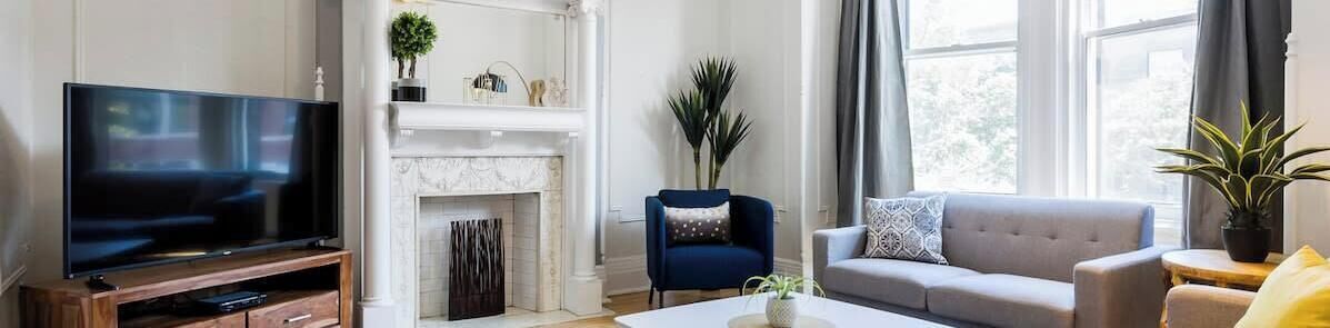 Una sala de estar con televisión, chimenea, sofá y mesa de centro.