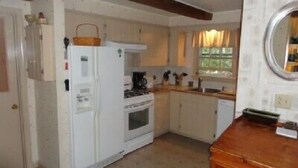 A compact kitchen with white cabinets, a white refrigerator, a wooden countertop, and a window with curtains. - Mount Desert Island, Bar Harbor, Acadia National Park (Bar Harbor)