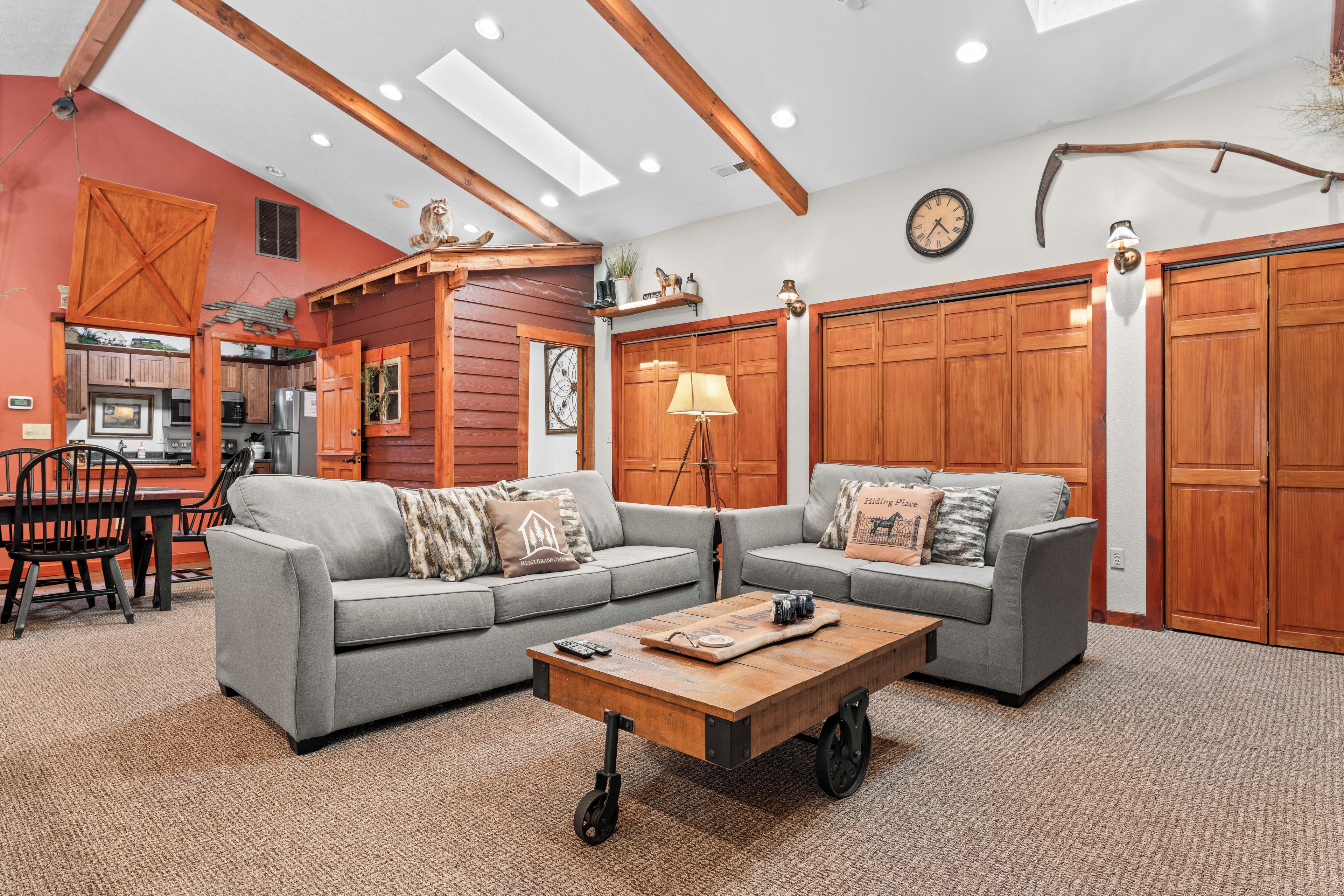 Ein Wohnzimmer mit zwei grauen Sofas, einem Couchtisch und einem Essbereich mit Tisch und Stühlen.