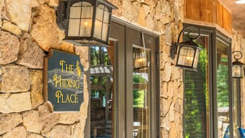 A stone wall with a sign reading 'The Hiding Place' and two lantern-style lights.