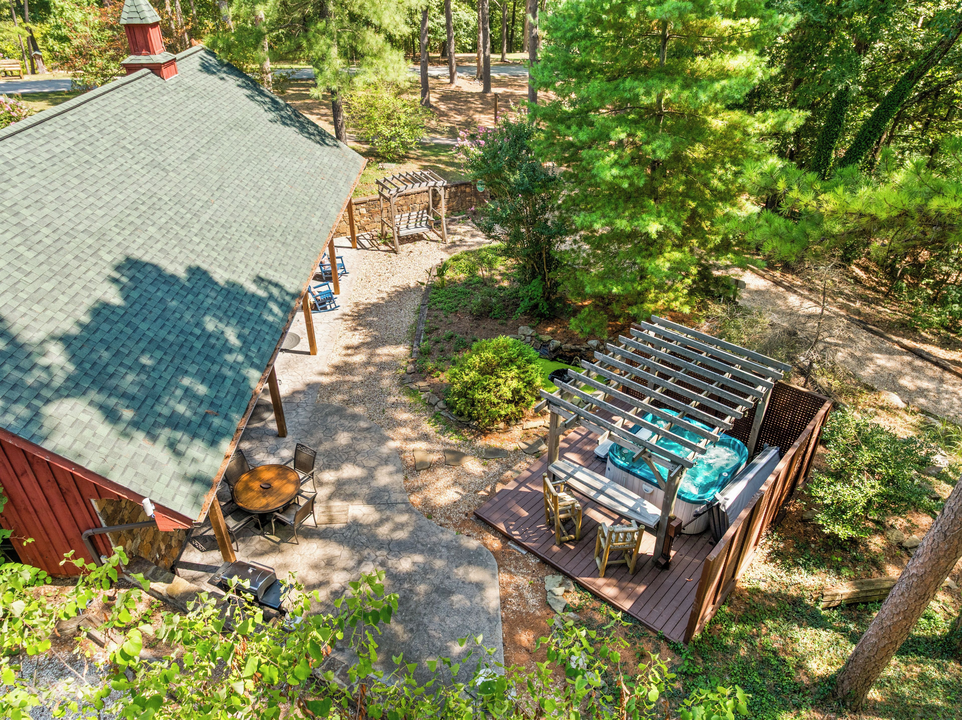 A patio area with a hot tub, wooden deck, and outdoor seating.