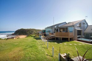 A modern beachfront property with a large patio, a swimming pool, and a view of the ocean. - Northern Beaches beachfront house . (Warriewood)
