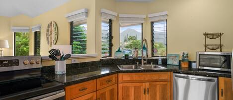 A modern kitchen with wooden cabinets, a stainless steel dishwasher, and a black stove.