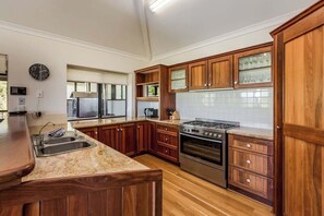 A kitchen with wooden cabinets, a stainless steel stove, and a microwave.