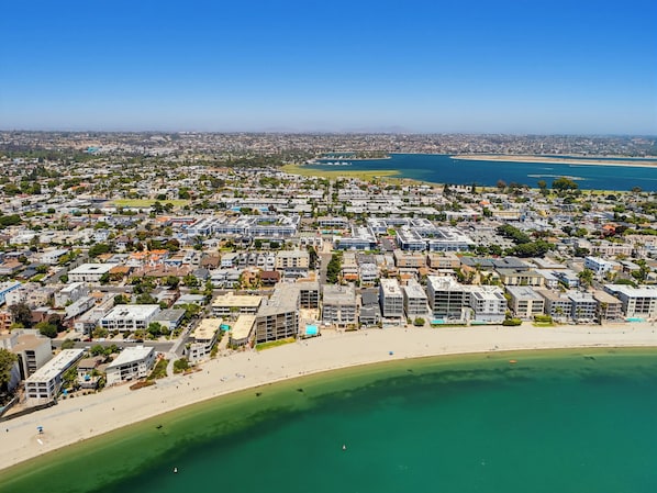 A coastal cityscape with residential buildings, a beach, and a marina.