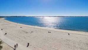 Uma praia com céu claro e mar calmo.
