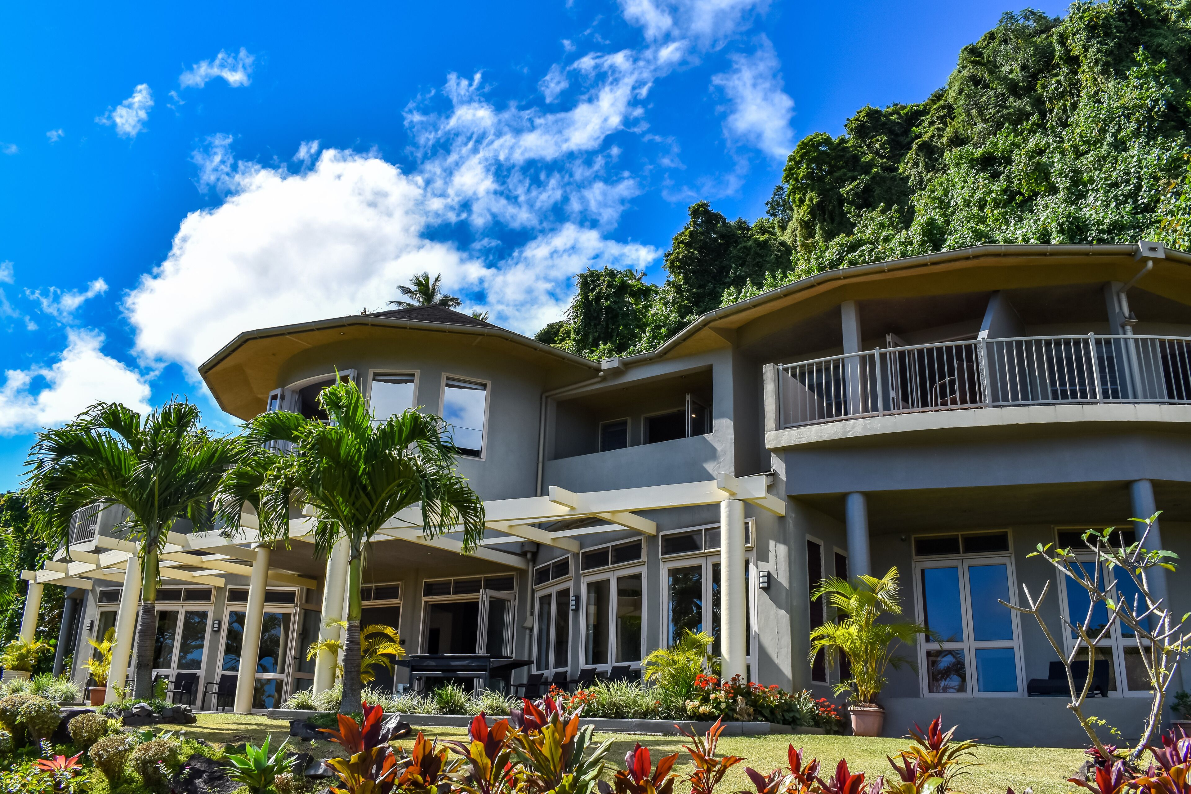 A large, modern two-story building with a covered outdoor area and a balcony.