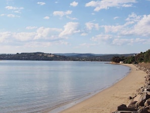 A beach with a rocky shoreline and a view of distant hills.