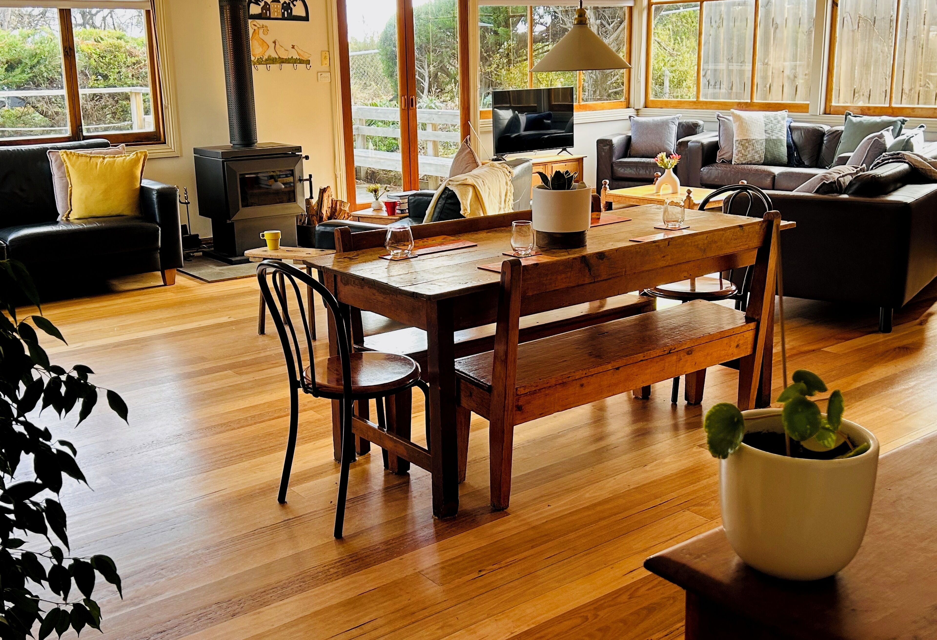 Un salon chaleureux avec une table à manger en bois, un canapé et un téléviseur.