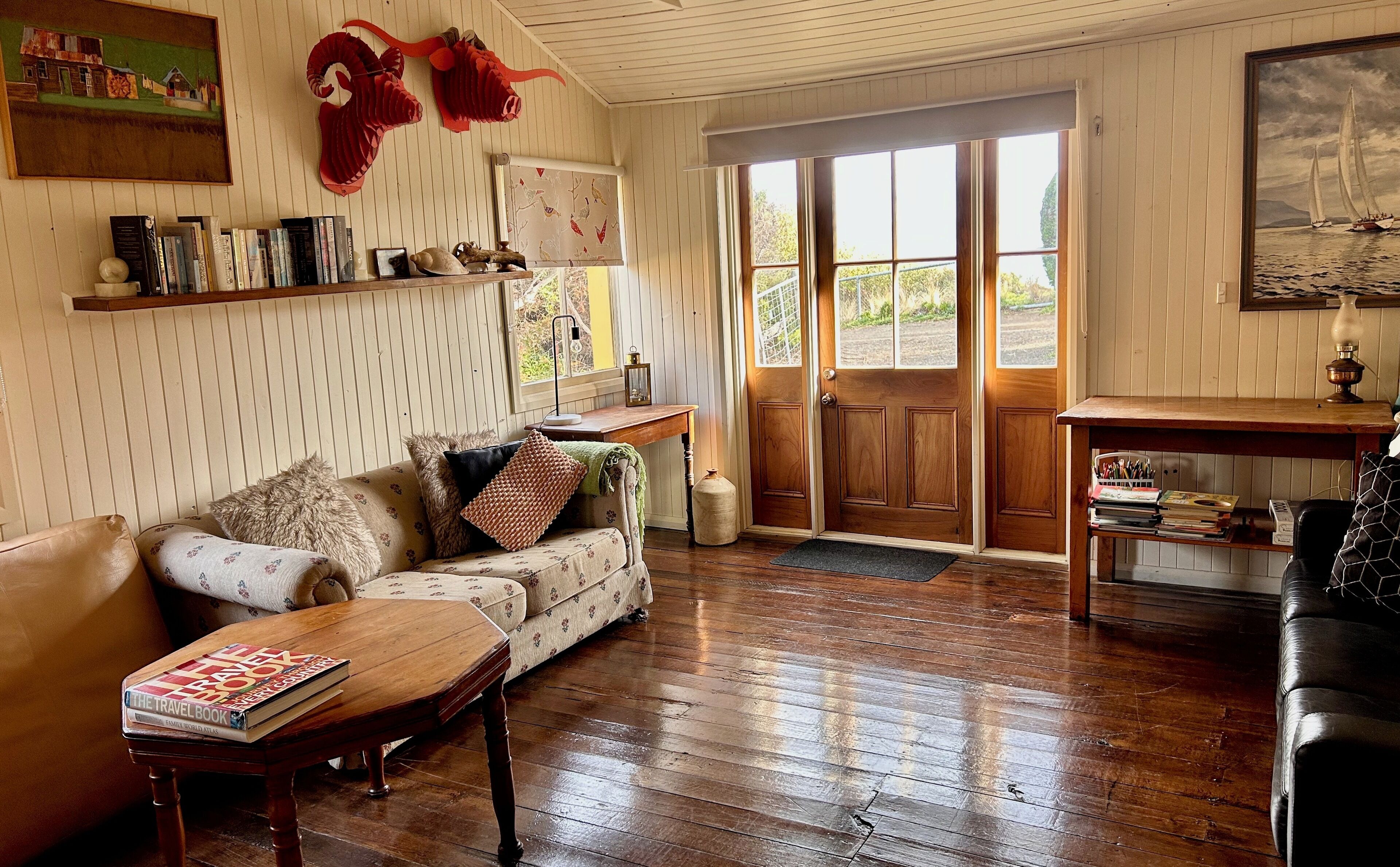 Un salon chaleureux avec un plancher en bois, un canapé, une table basse et une bibliothèque.