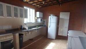 A kitchen with a stove, microwave, refrigerator, and cabinets. - Chacara Dois Lagos!   Come and admire nature in this place!   (ITU)
