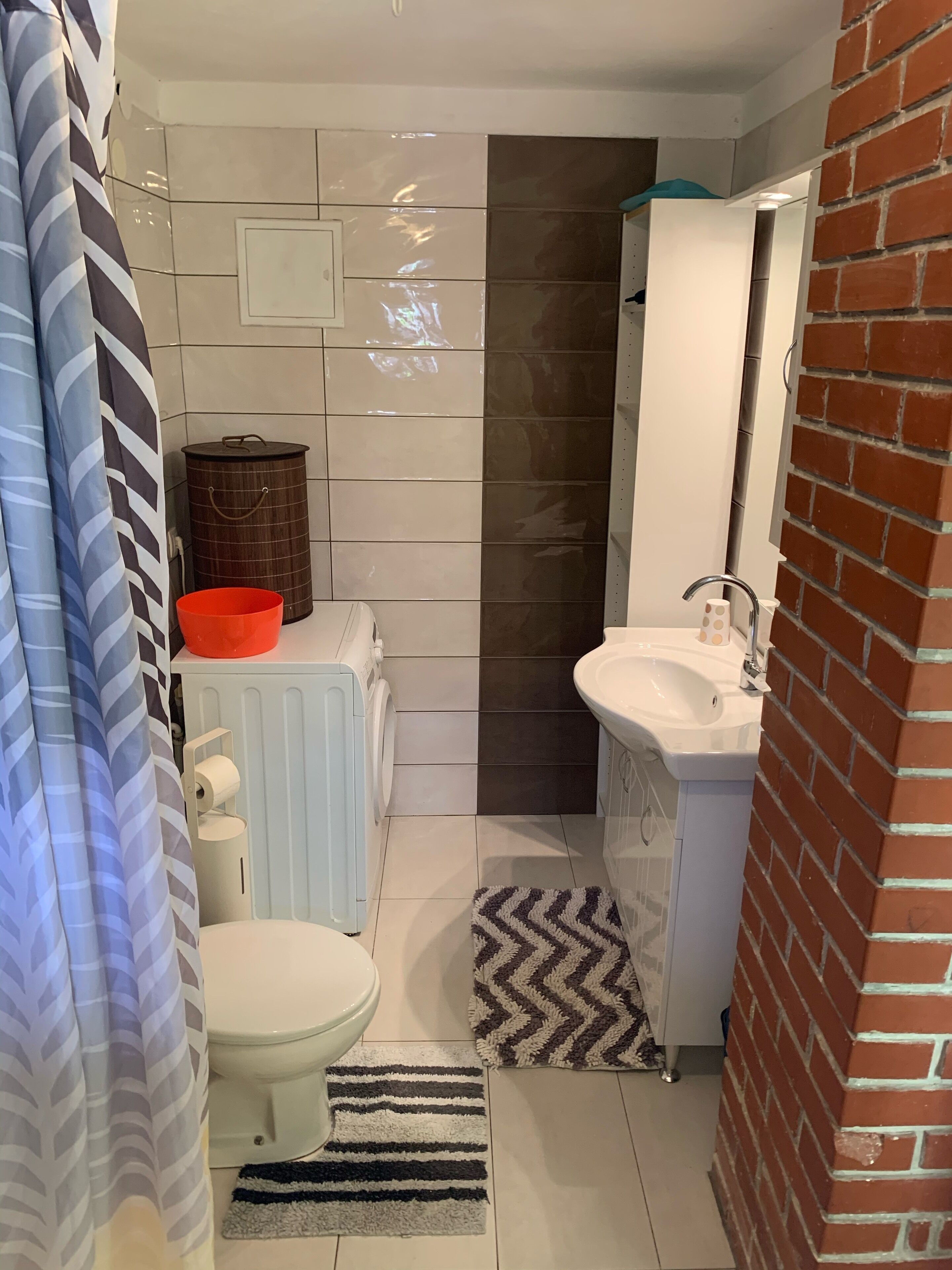 Un bagno compatto con WC, lavandino e zona doccia.