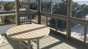 Un ambiente luminoso con una mesa grande y vistas al océano y a las casas.