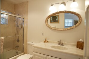 Enjoy a refreshing shower in the glass-enclosed shower with a handheld showerhead and faucet.