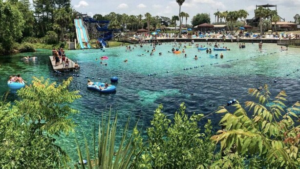 A water park with a large pool, inflatable rafts, and a water slide. -  3 Bed ~ 2 Bath~  Pool ~ Wifi ~ Pets Welcome ~Optional Heated Pool ~SS Barbecue  (Spring Hill)