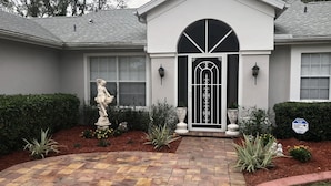 A house with a gated entrance, a statue, and a security sign. -  3 Bed ~ 2 Bath~  Pool ~ Wifi ~ Pets Welcome ~Optional Heated Pool ~SS Barbecue  (Spring Hill)